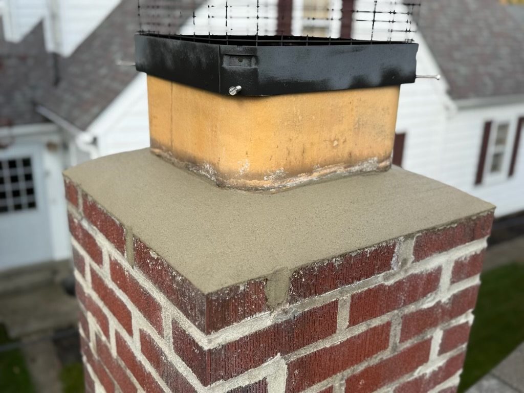 Rebuilt brick chimney with a new concrete crown