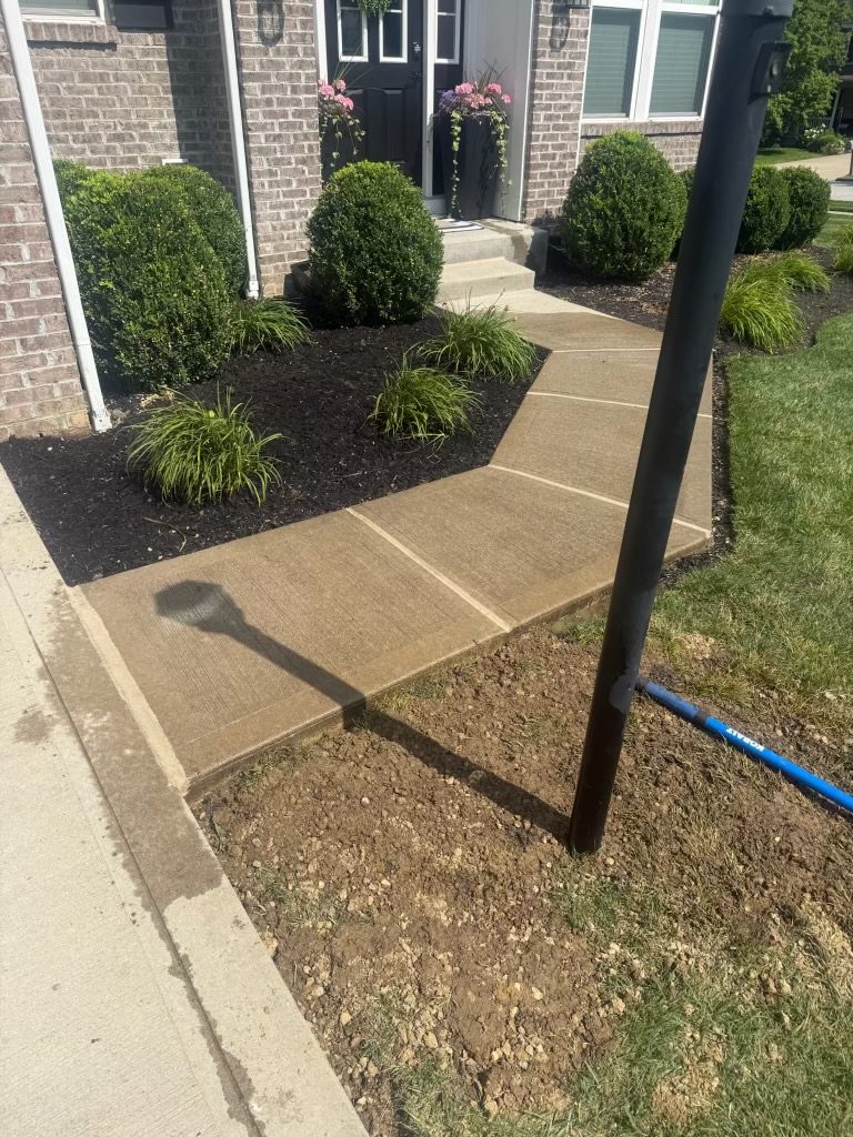 Finished walkway and fresh landscaping at a home entrance